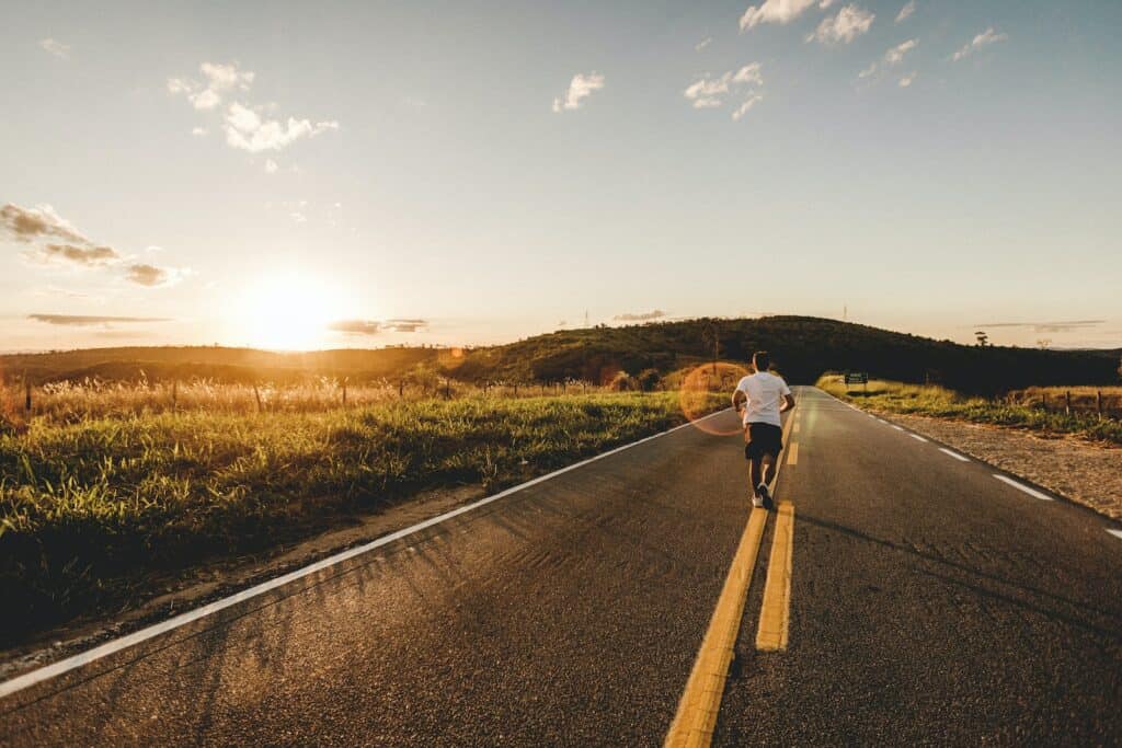 person running in road during daytime, road running