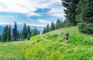 man running in a grassy field, trail running