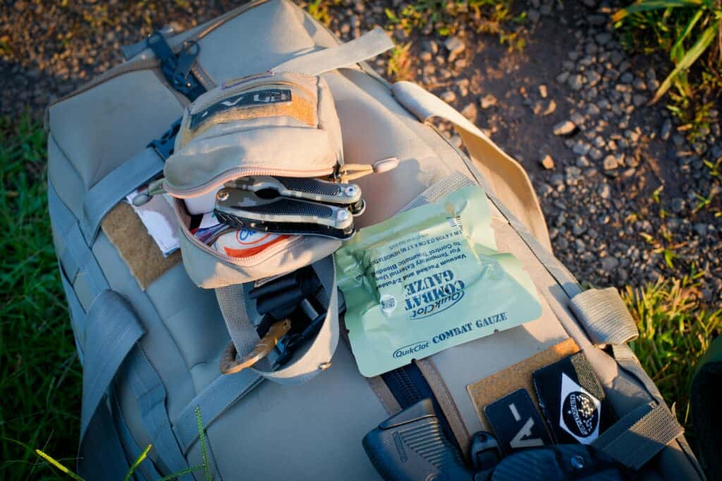 Khaki Backpack with Survival Kit on the Ground