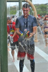 A man washing shoes under a shower