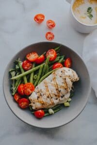 bowl of vegetables with chicken breast on top