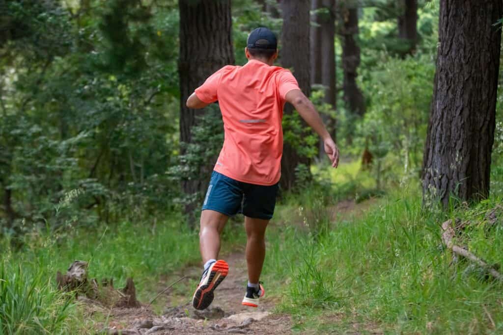 a man running in the woods on a trail